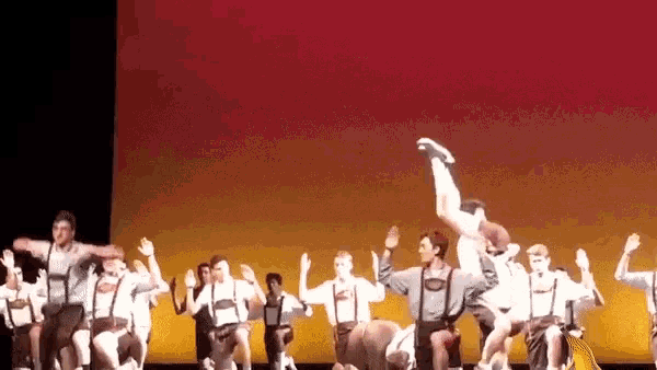 a group of people are performing a dance on a stage