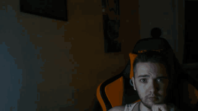 a man sitting in an orange and black chair with the word akracing on it