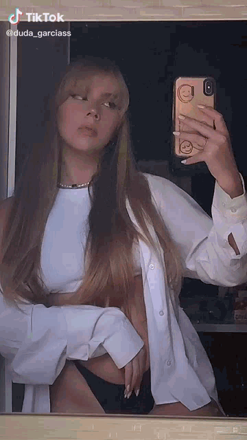 a woman is taking a picture of herself in a mirror .