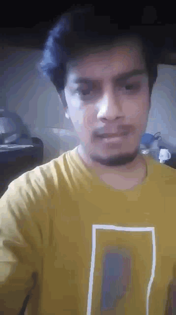 a man with a beard is wearing a yellow t-shirt with the letter l on it