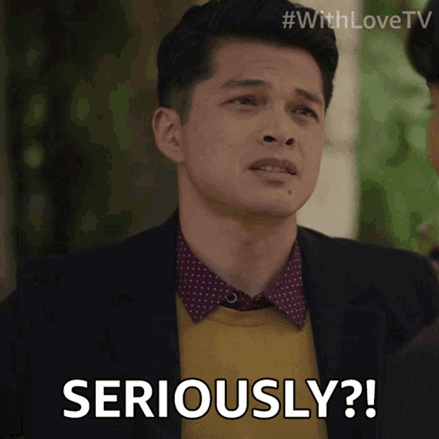 a man wearing a suit and a yellow sweater says " seriously "