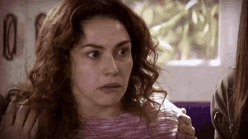 a woman with curly hair is making a funny face .
