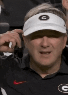 a man wearing a white hat with a g on it