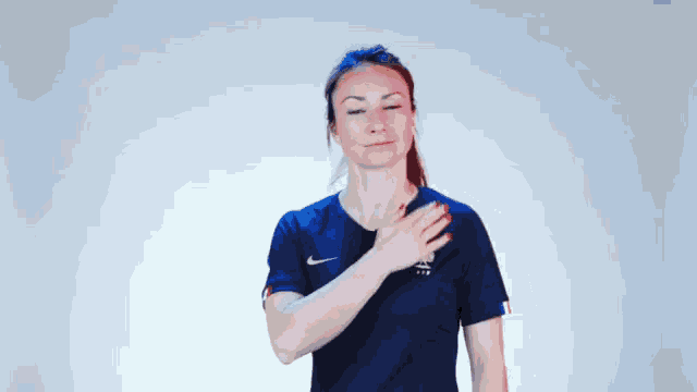a woman wearing a blue nike shirt with a rooster on the front