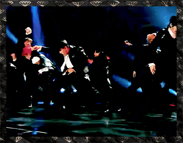 a group of men are dancing on a stage with a diamond border around them