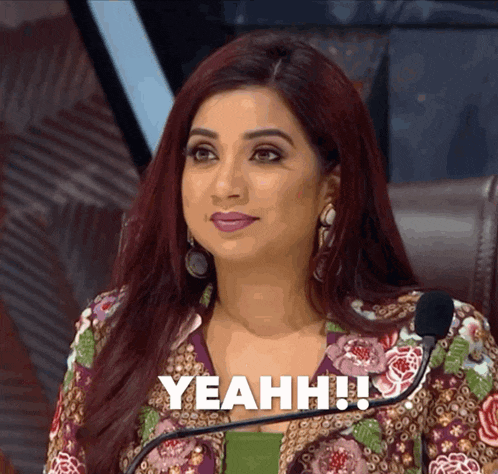 a woman sitting in front of a microphone with the words yeahh written on her face