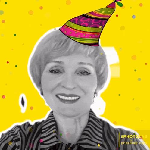 a woman wearing a colorful party hat is smiling