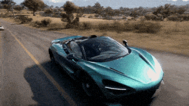 a green sports car is driving down a road