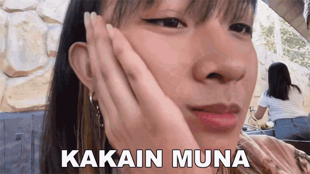 a close up of a woman 's face with the words kakain muna written on the bottom
