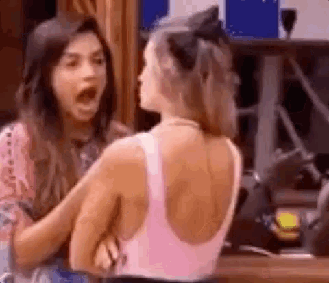 two women are having a fight in a room and one of them is screaming .