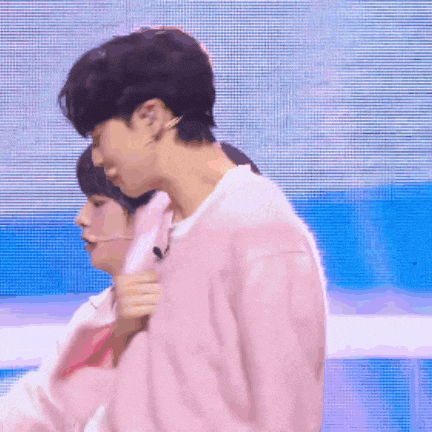 a man in a pink sweater is standing next to a woman in a white shirt .