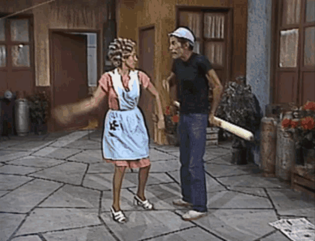 a man and a woman are dancing on a patio and the woman is wearing an apron with the letter e on it