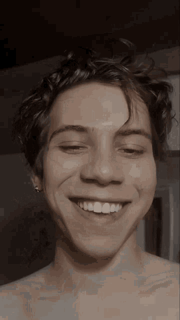a young man without a shirt is smiling for the camera