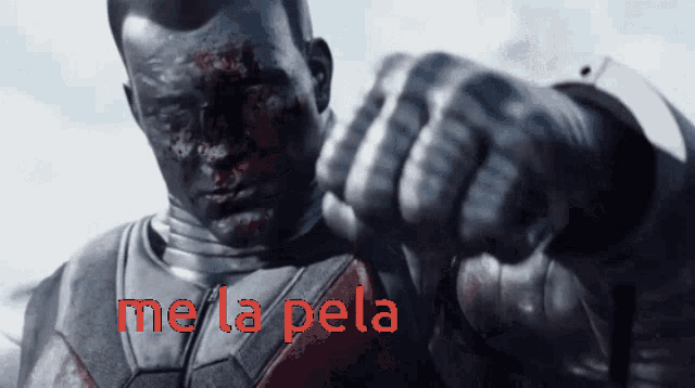 a close up of a man 's fist with the words me la pela behind him