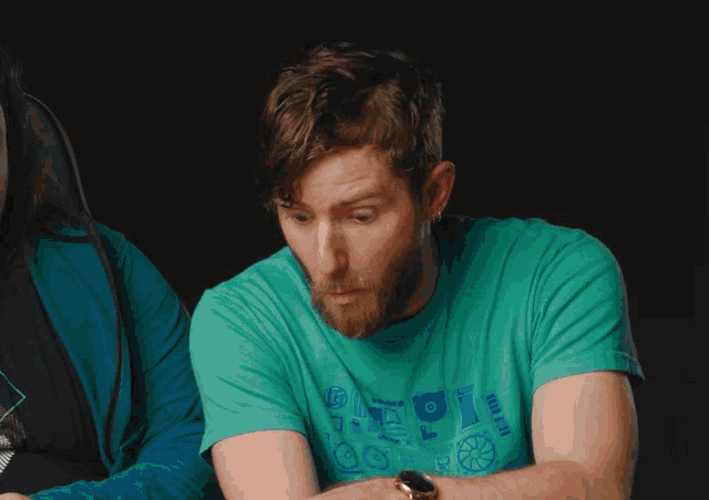 a man with a beard wearing a green shirt with the word pi on it