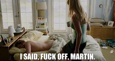 a woman is sitting on a man 's lap on a bed and says `` i said , fuck off , martin ''