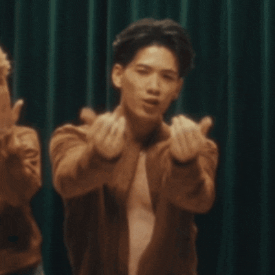 a man without a shirt is making a heart with his hands