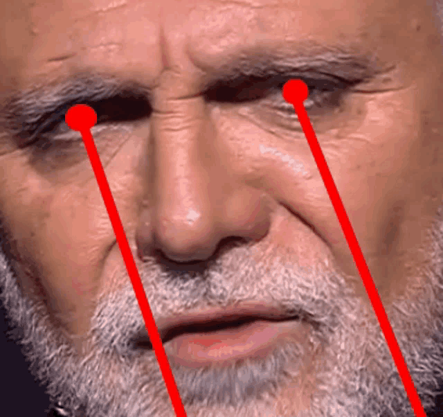 a close up of a man 's face with red eyes