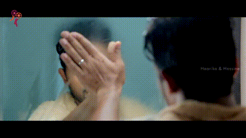 a man is looking at himself in a mirror with the words haarika & hassine on the bottom right