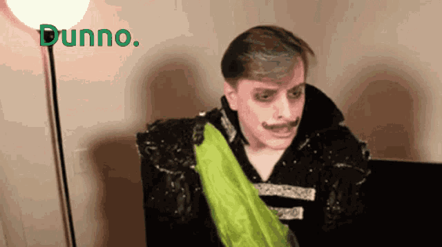a man with a green scarf around his neck and dunno written in green