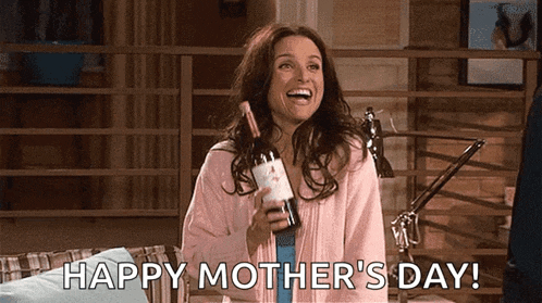 a woman is holding a bottle of wine and smiling .