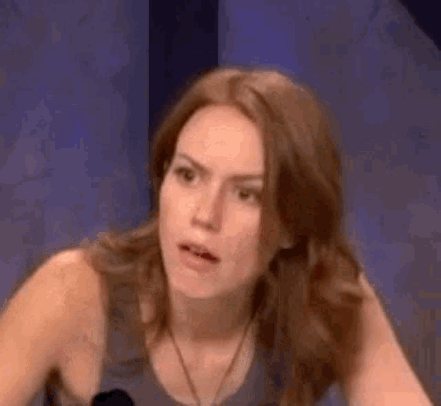 a woman is making a funny face while sitting at a table .