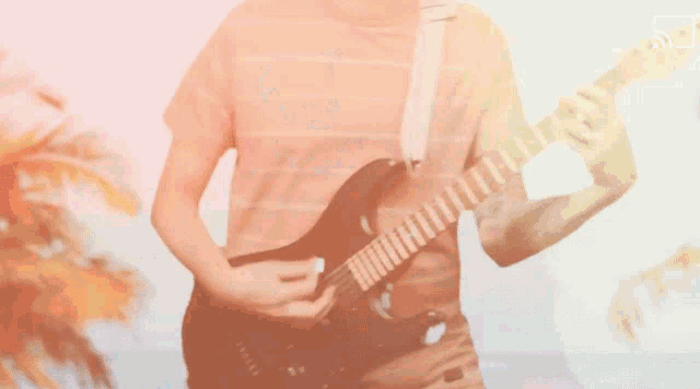 a man in a striped shirt is playing a guitar
