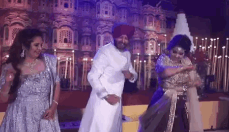 a group of people are dancing on a stage at a wedding .