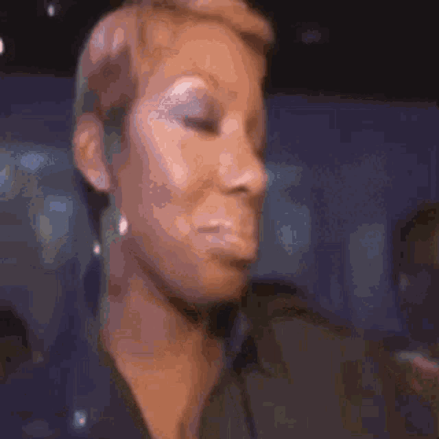 a woman is making a funny face with her eyes closed .