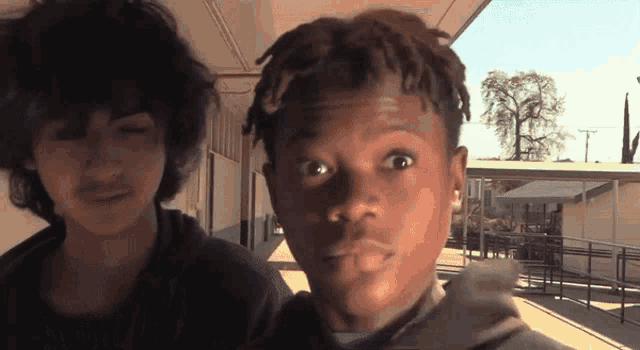 a young man with dreadlocks looks at the camera