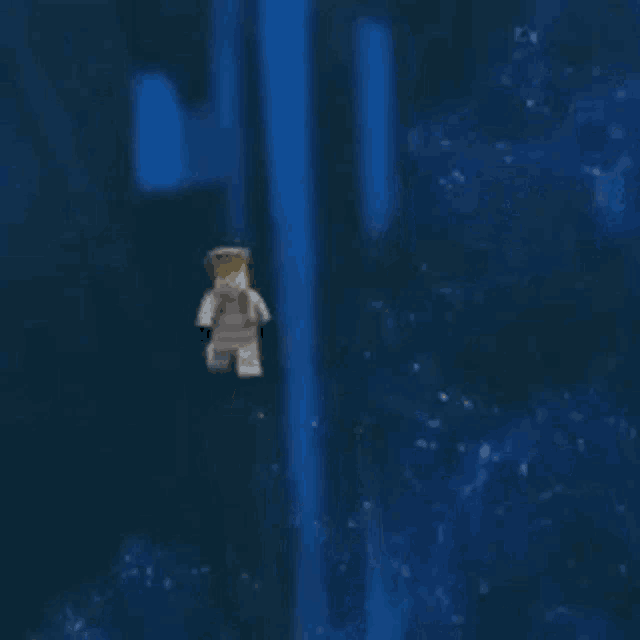 a lego figure is floating in the air in a dark room .