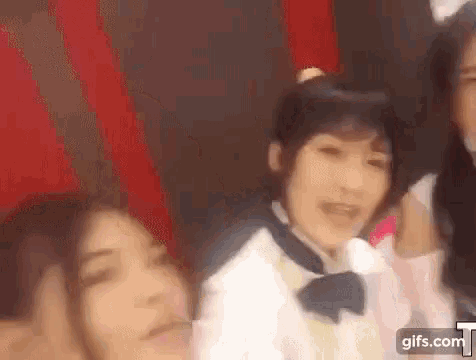 a group of girls are standing next to each other in a room and looking at the camera .