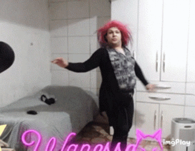 a woman with pink hair is dancing in a room with the word imgplay written in pink