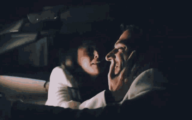 a man and a woman are sitting in the back seat of a car .