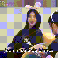 a woman wearing a bunny ear headband is sitting on a couch next to another woman .