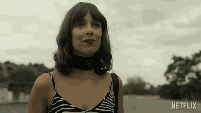 a woman wearing a choker and a striped tank top with a netflix logo in the corner