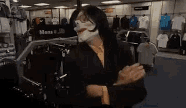 a man wearing a clown mask is clapping his hands in a store .