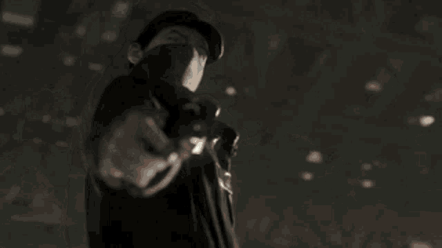 a man with a mask on his face is holding a gun in his hand .