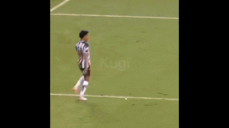 a soccer player is jumping in the air while another player kicks the ball .