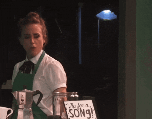 a woman stands behind a sign that says " tip for a song "