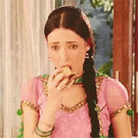 a woman in a pink dress is eating a banana and making a funny face .