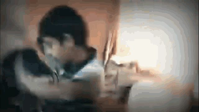 a blurry picture of a man and woman kissing in a bedroom .