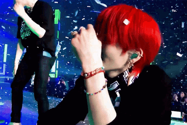 a person with red hair is wearing a bracelet that says love