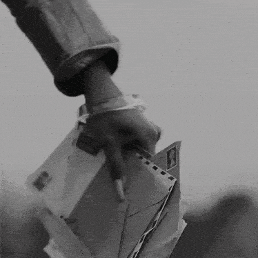 a black and white photo of a person holding a pile of letters