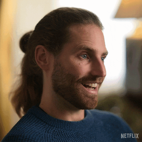 a man with a ponytail and a beard is smiling in a netflix advertisement