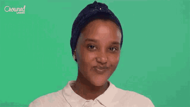 a woman with a turban on her head is rubbing her face with her hands .