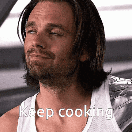 a man with a beard wearing a white tank top with the words keep cooking on it