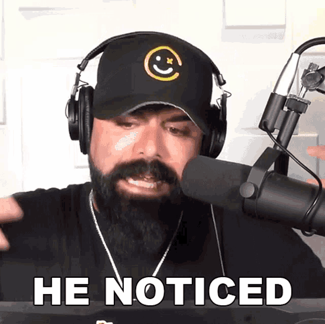 a man wearing headphones and a hat says " he noticed "