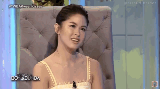 a woman is sitting in a chair with the words tonight boy abunda written on the bottom