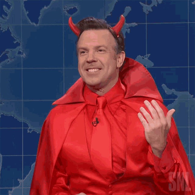 a man dressed in a devil costume with a snl logo in the background